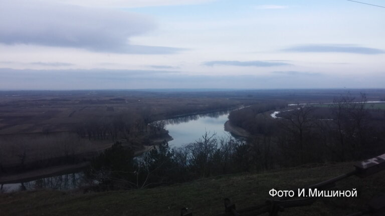 Над рекою село в серой дымке тумана